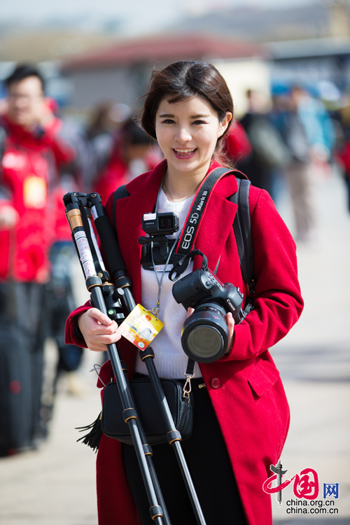 2016年兩會，人民大會大堂前，一位笑容燦爛的紅衣女記者正步入大會堂。中國網(wǎng) 鄭亮 攝