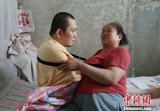 身體日漸衰老的梁青蘭每次幫兒子翻身、坐立,全身的衣物都要濕透一次。 尚明俠 攝