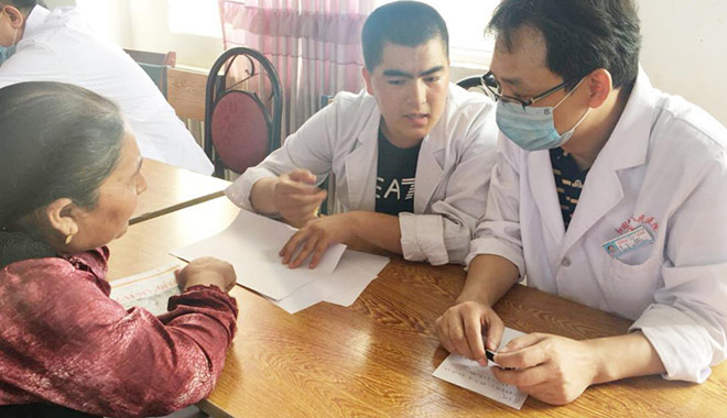 圖為曾建平醫師(右)下鄉義診