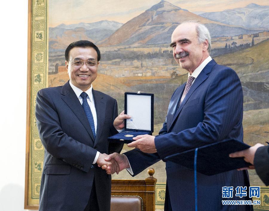 6月19日，國務院總理李克強在希臘議會大廈會見希臘議長米馬拉基斯。這是會見前，米馬拉基斯代表希臘議會向李克強授予議會金質勛章。新華社記者 王曄 攝